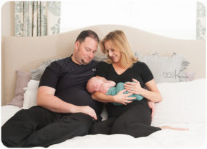 family on bed with newborn