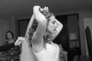 bride getting ready by Maryland wedding photographer, Nina K, putting on veil, black and white photography