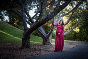 Maternity photography by Maryland family photographer, Nina K, woman in red long dress outdoors